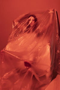 Close-up of woman with pink flower in bed