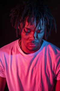 Portraits of beautiful african young man under blu and red lights