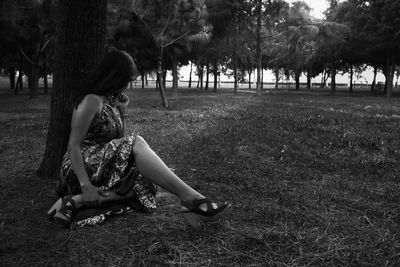Woman sitting on field in park