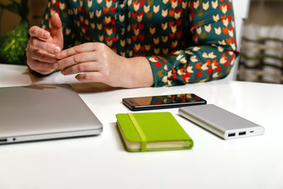 Midsection of man using smart phone on table