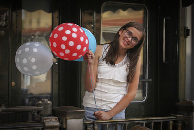 Portrait of girl holding balloons