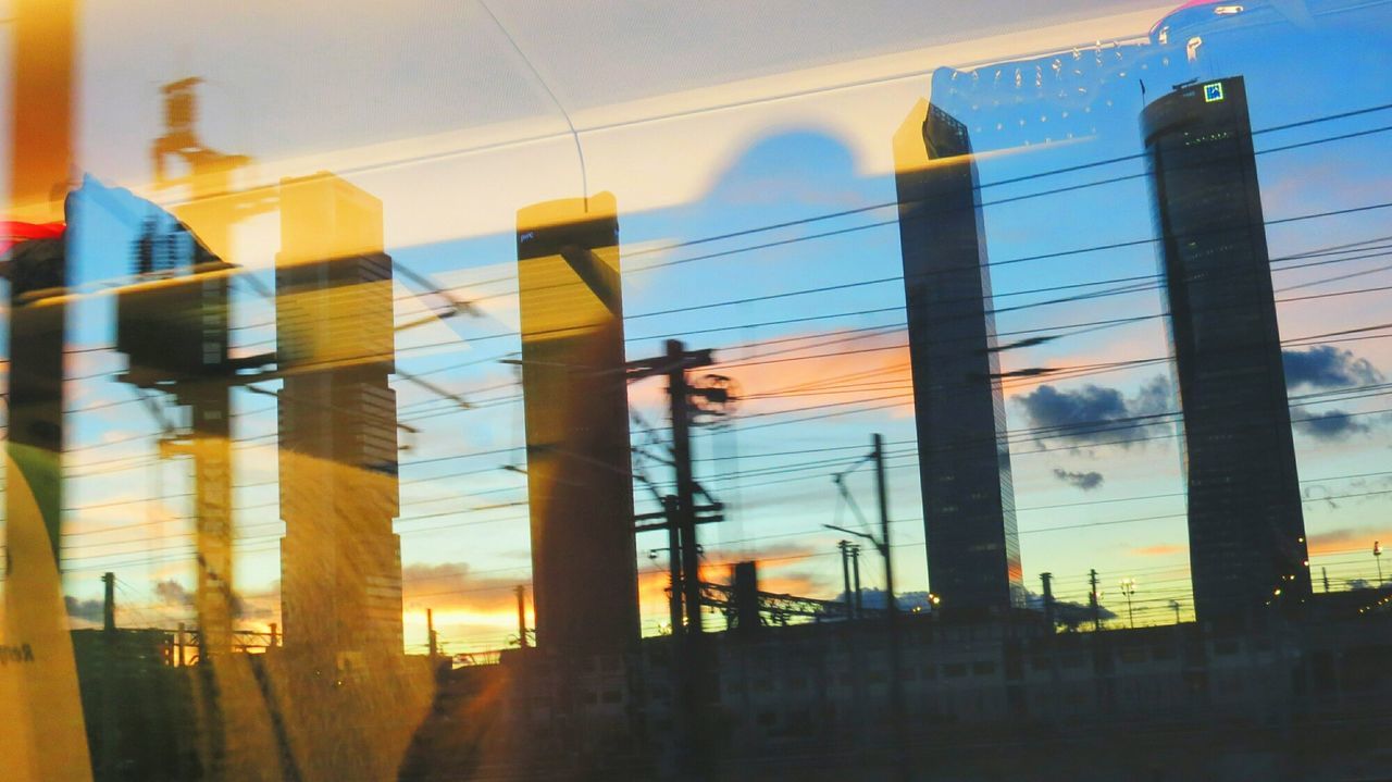 architecture, built structure, building exterior, sunset, sky, city, building, silhouette, reflection, cloud - sky, low angle view, dusk, outdoors, no people, orange color, cloud, architectural column, water, modern, pole