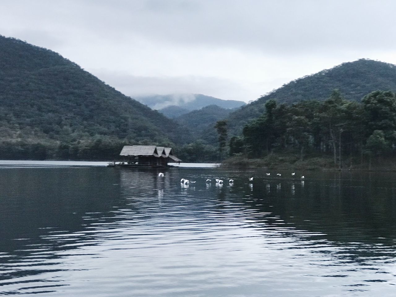 mountain, water, built structure, nature, mountain range, day, tranquility, beauty in nature, waterfront, outdoors, tranquil scene, scenics, lake, architecture, no people, sky, cloud - sky, tree, building exterior