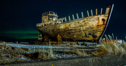 Abandoned ship at beach at night