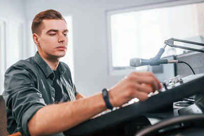 Setting the equipment. young man is indoors in the radio studio is busy by broadcast.