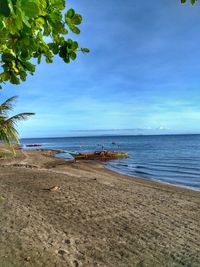 Scenic view of beach against blue sky