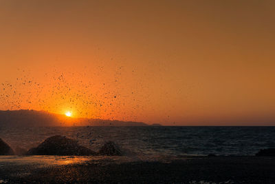 Scenic view of sea against orange sky