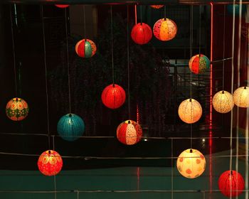 Low angle view of illuminated lanterns hanging at night