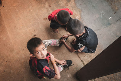 High angle view of siblings playing on floor