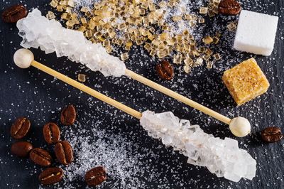 High angle view of sugar with roasted coffee beans on table