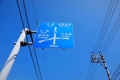 Low angle view of electricity pylon against clear blue sky