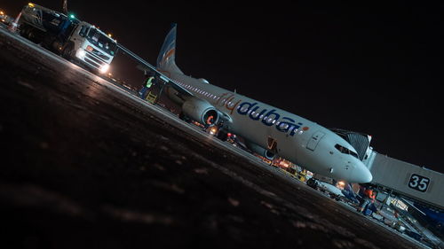 Airplane on runway against clear sky at night