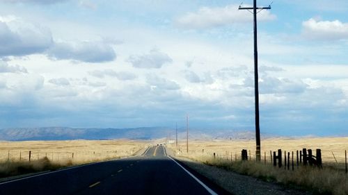 Road by landscape against sky