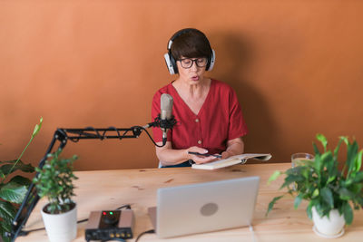 Senior woman with laptop sitting at table