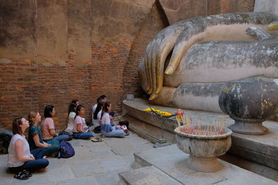 People sitting outside temple