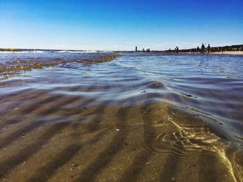 Scenic view of beach against blue sky