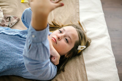 Portrait of cute baby boy lying on bed at home