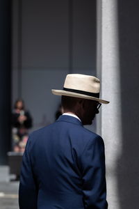 Rear view of man standing against wall