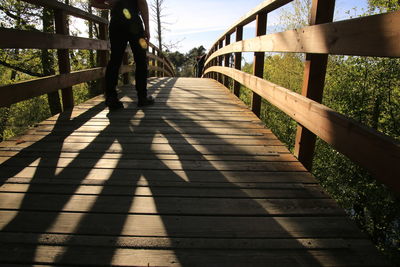 Surface level of narrow footbridge against sky