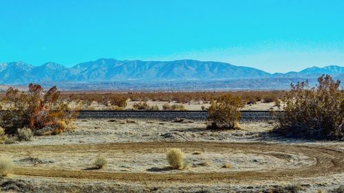 Scenic view of desert against blue sky