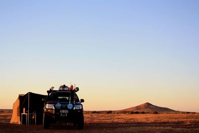 Boat on land against clear sky during sunset