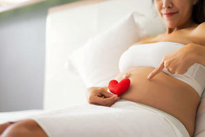 Midsection of woman lying on bed