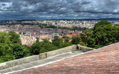 View of cityscape against cloudy sky