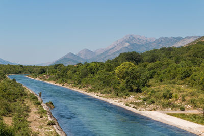 Scenic view of landscape and mountains against clear sky