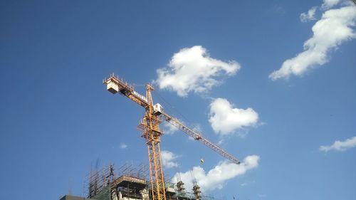 Low angle view of crane against blue sky