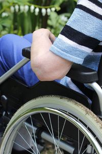 Midsection of man sitting on wheelchair