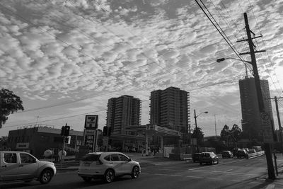 Cars on road by city against sky