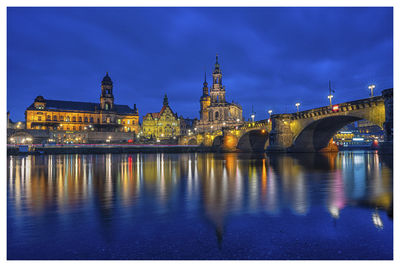 Illuminated bridge over river at night