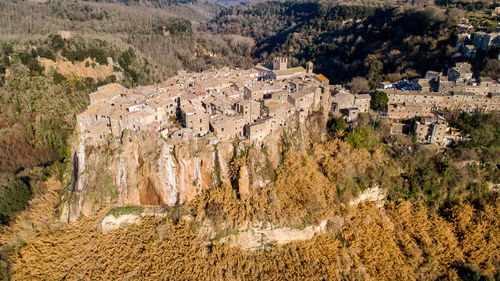 Aerial view of calcata, italy. the medieval town lays on a volcanic cliff, near the treja river.