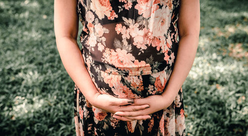 Midsection of woman standing on field