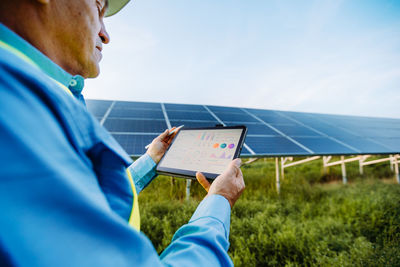 Engineer is holding tablet. settings of solar system. alternative energy concept