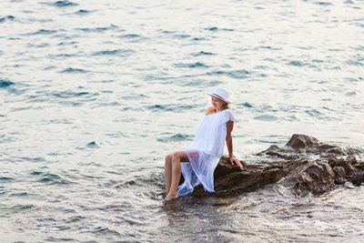 Full length of woman sitting on beach