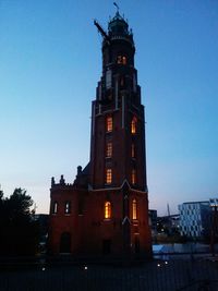 Illuminated clock tower against sky at night