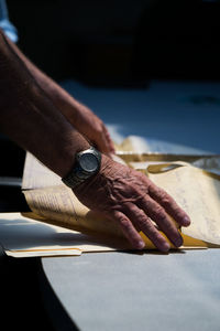 Close-up of man holding paper on table