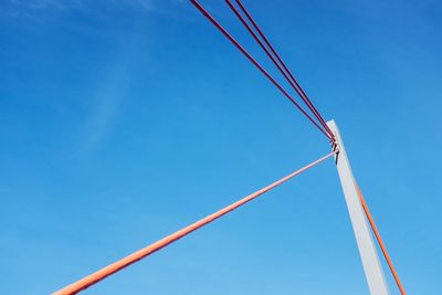 Low angle view of cables against clear blue sky