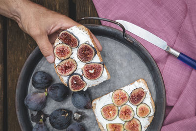 Hand eating ricotta sandwich with fresh figs