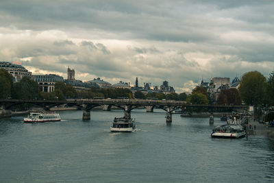 Bridge over river against cloudy sky