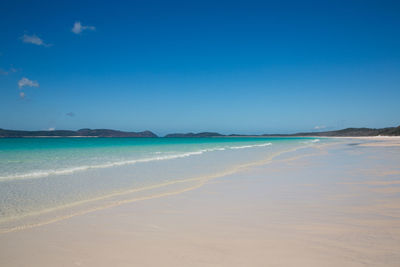 Scenic view of beach against clear blue sky