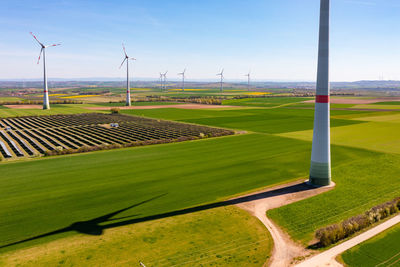 Aerial view of wind turbines and solar panels of a solar park between fields in rhineland, germany