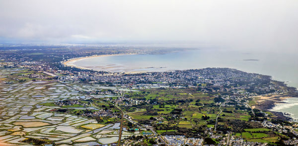 High angle view of city by sea against sky