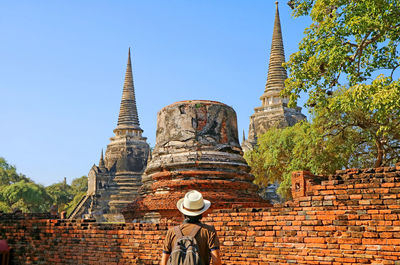 Visitor being impressed by pagoda ruins of wat phra si sanphet, ayutthaya historical park, thailand