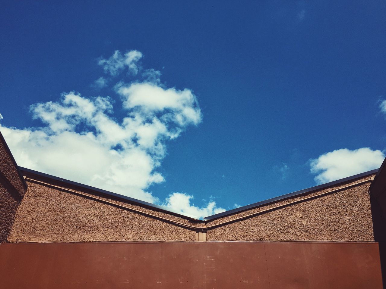 LOW ANGLE VIEW OF HOUSE AGAINST BLUE SKY