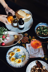 Springtime meal dinner lunch spread on floral table with hands placing food