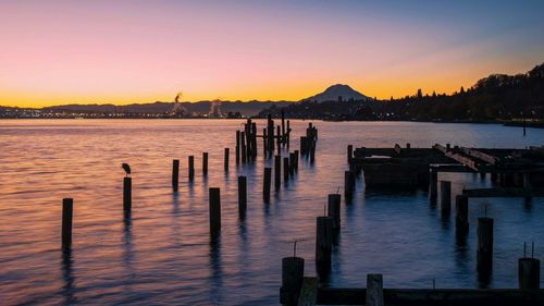 Pier over sea against sky during sunset