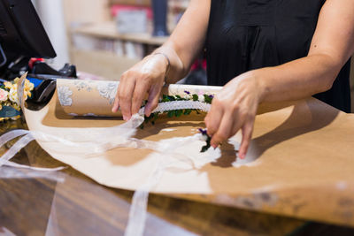 Midsection of woman holding food on table