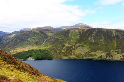 Scenic view of lake by mountains against sky
